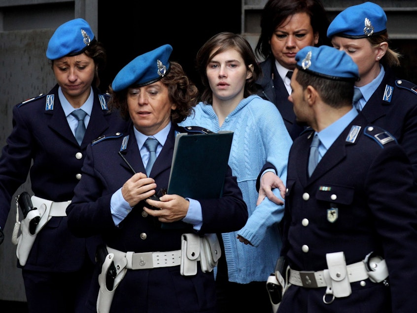 caption: Police officers lead Amanda Knox from the Court of Appeal in Perugia, Italy, in November 2010.