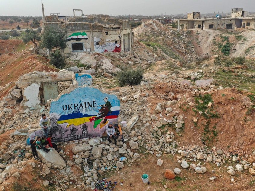 caption: As Russian forces began their invasion of Ukraine last week, artists in the Syrian city of Binnish painted a mural to show solidarity with Ukraine. It was painted on what's left of a home destroyed by Russian aircraft during Syria's civil war.