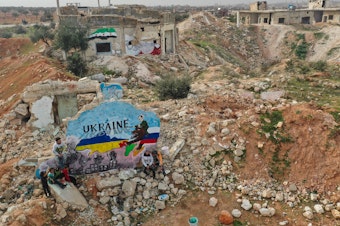 caption: As Russian forces began their invasion of Ukraine last week, artists in the Syrian city of Binnish painted a mural to show solidarity with Ukraine. It was painted on what's left of a home destroyed by Russian aircraft during Syria's civil war.