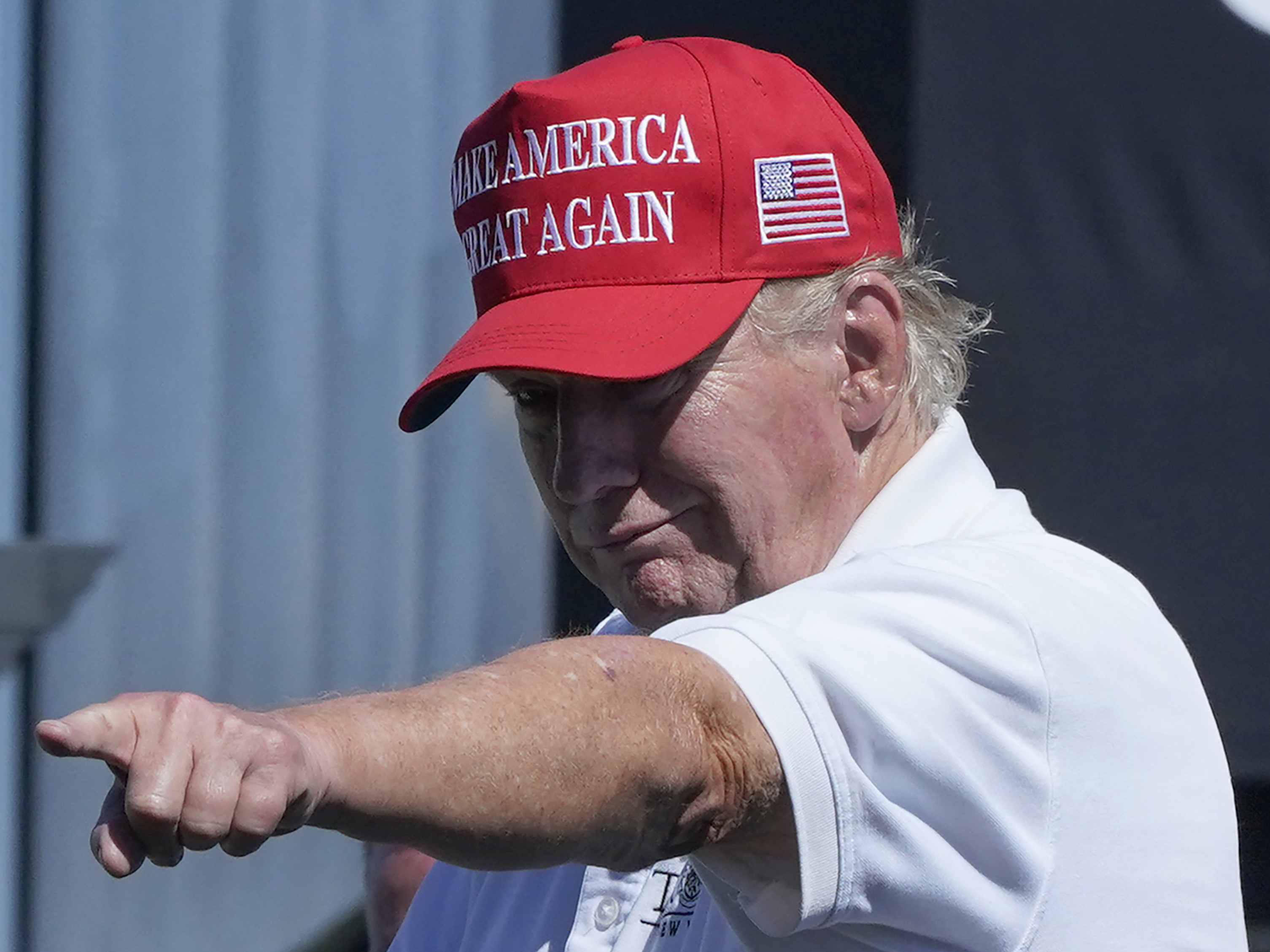 caption: Former President Donald Trump points at a crowd at a golf tournament at Trump National in Bedminster, N.J., on Sunday.