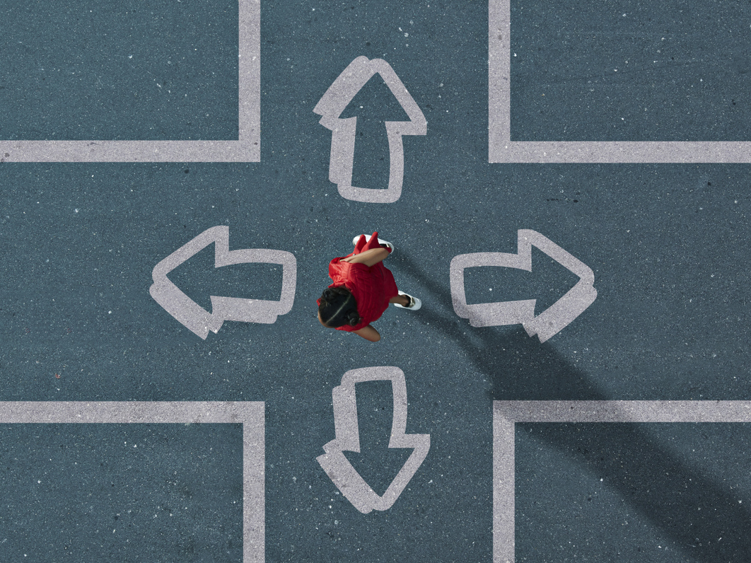 A young girl chooses from among arrows pointed in four different directions.