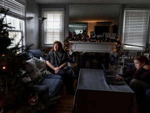 caption: Eileen Carroll, left, sits for a portrait as her daughter, Lily, 11, attends school remotely from their home in Warwick, R.I. on Dec. 16. When Carroll's other daughter tested positive for the coronavirus, state health officials told her to notify anyone her daughter might have been around. Contact tracers, she was told, were simply too overwhelmed to do it.