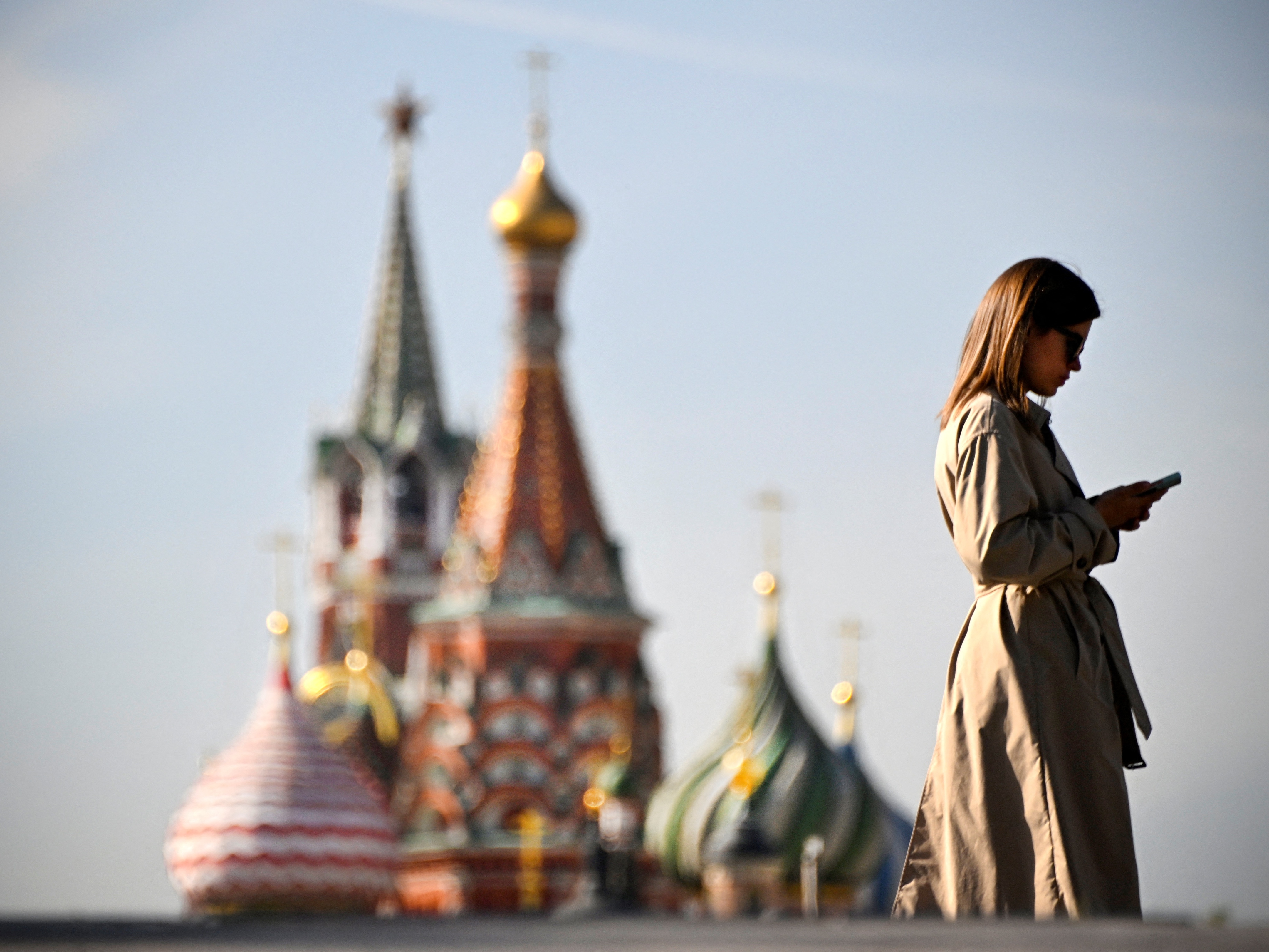 caption: A woman walks in front of the Kremlin on September 23, 2024. U.S. intelligence officials say Russia has embraced artificial intelligence tools to try to sway American voters ahead of the November election. 