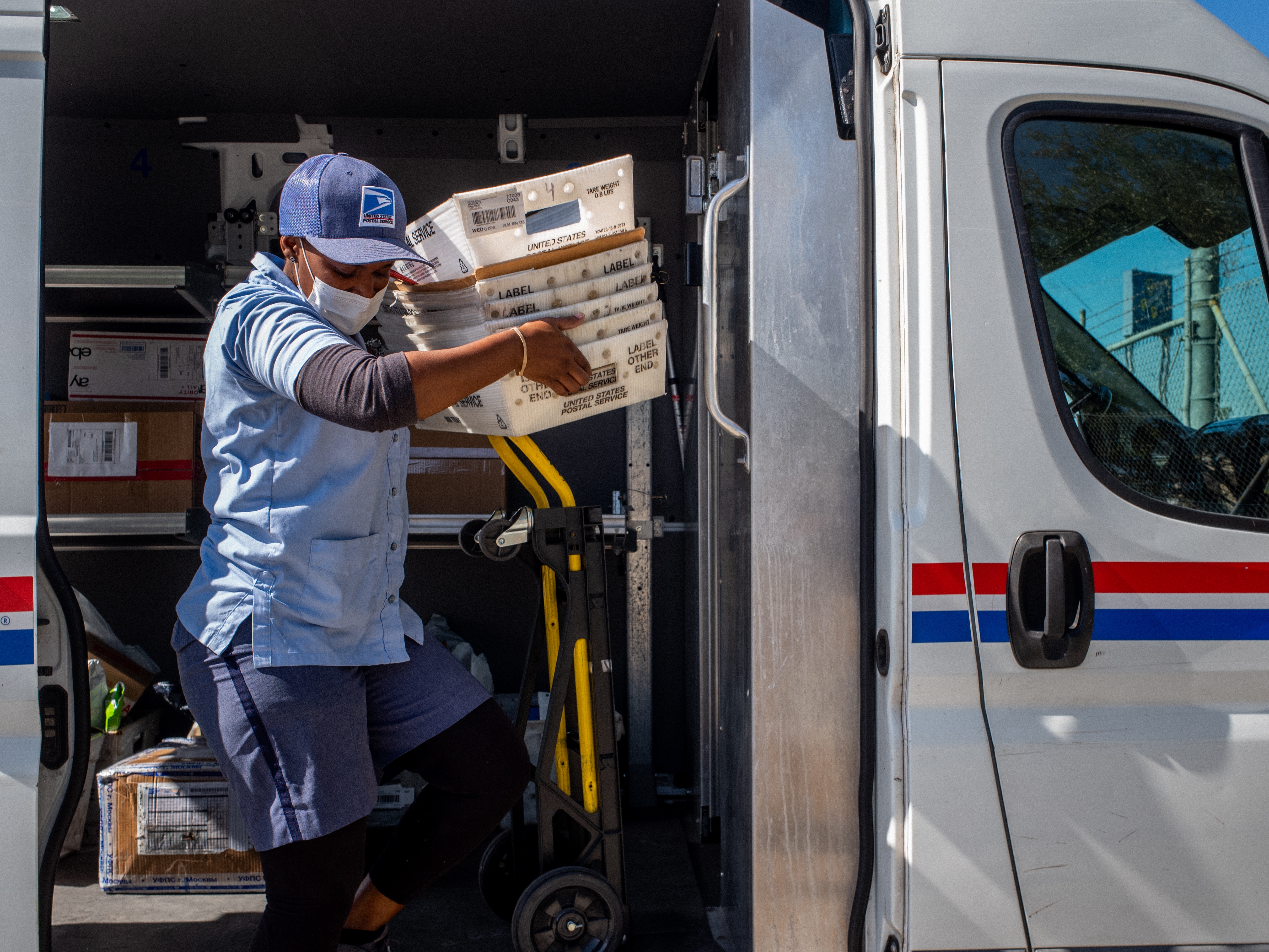 caption: A U.S. Postal Service employee unloads mail at a facility in 2022 in Houston.
