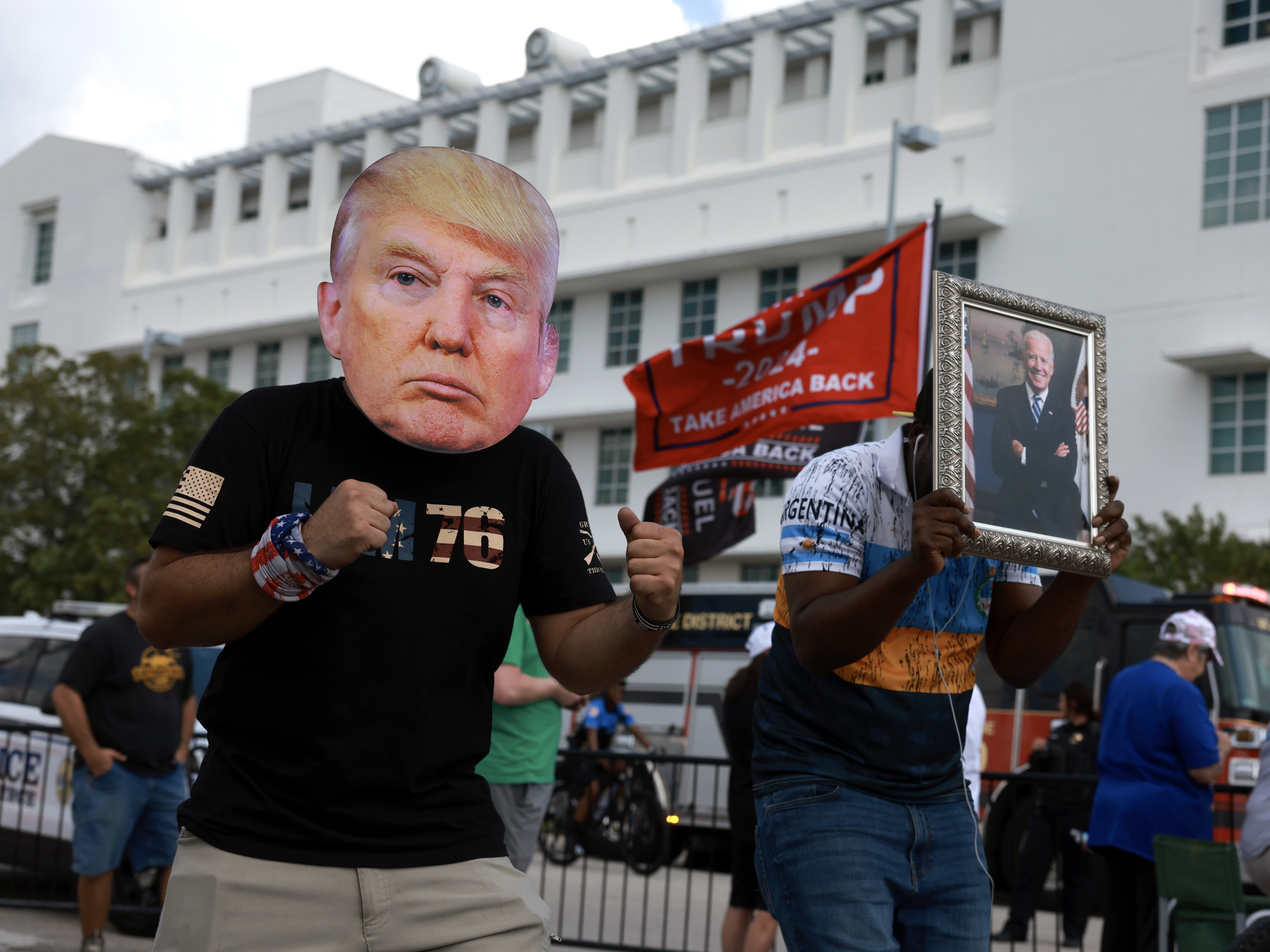 caption: A man wears a mask of Donald Trump in front of the Alto Lee Adams Sr. U.S. Courthouse in Florida on February 12.