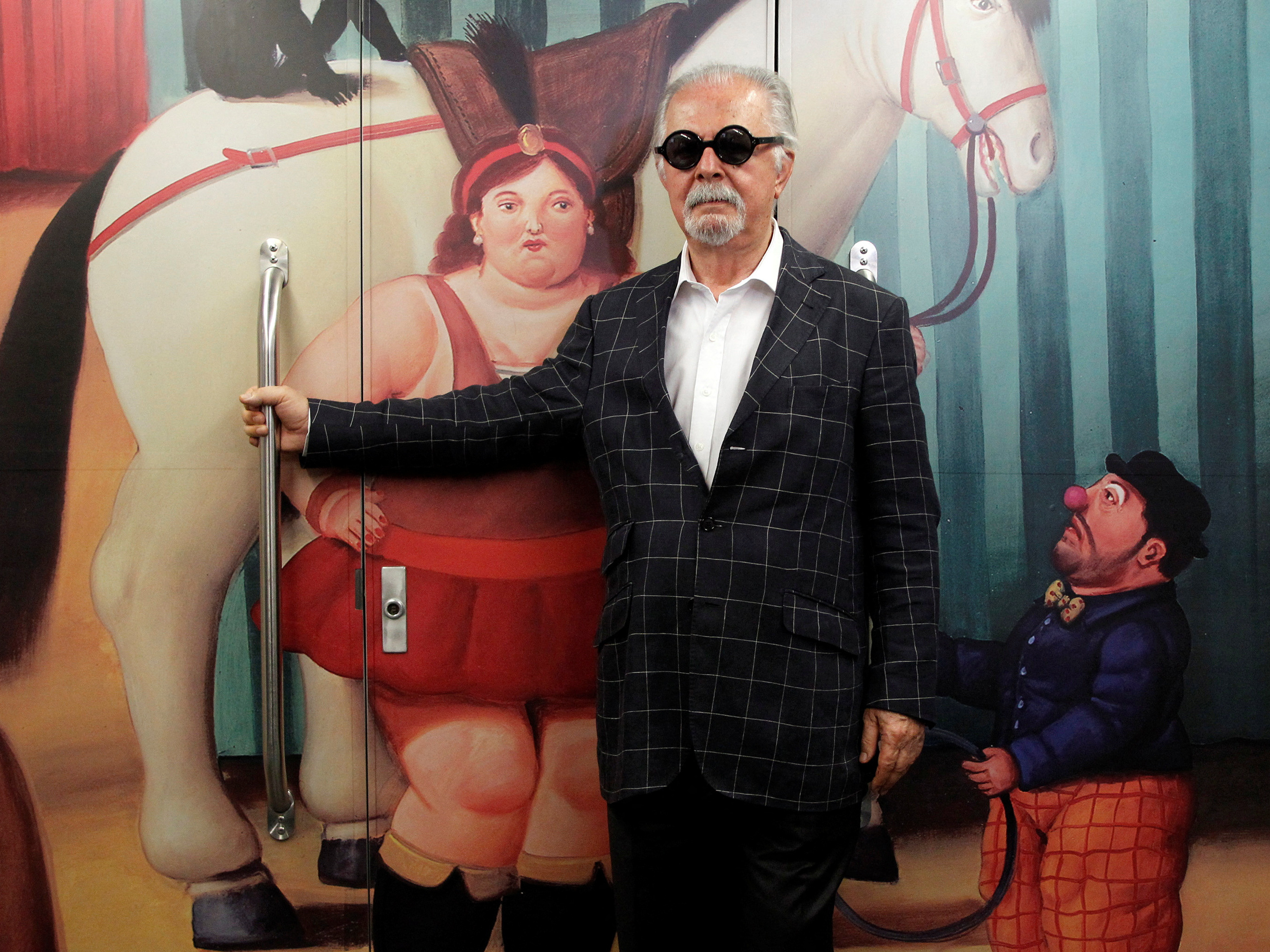 caption: Colombian painter and sculptor Fernando Botero poses inside the "<em>Tren de La Cultura"</em> ("Train of Culture"), during a news conference for the exhibition "Fernando Botero: The Circus," in Medellín, Colombia, Jan. 30, 2015.