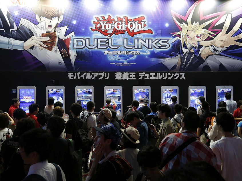 caption: Visitors play Yu-Gi-Oh! Duel Links at the Tokyo Game Show in 2016 in Chiba, Japan.