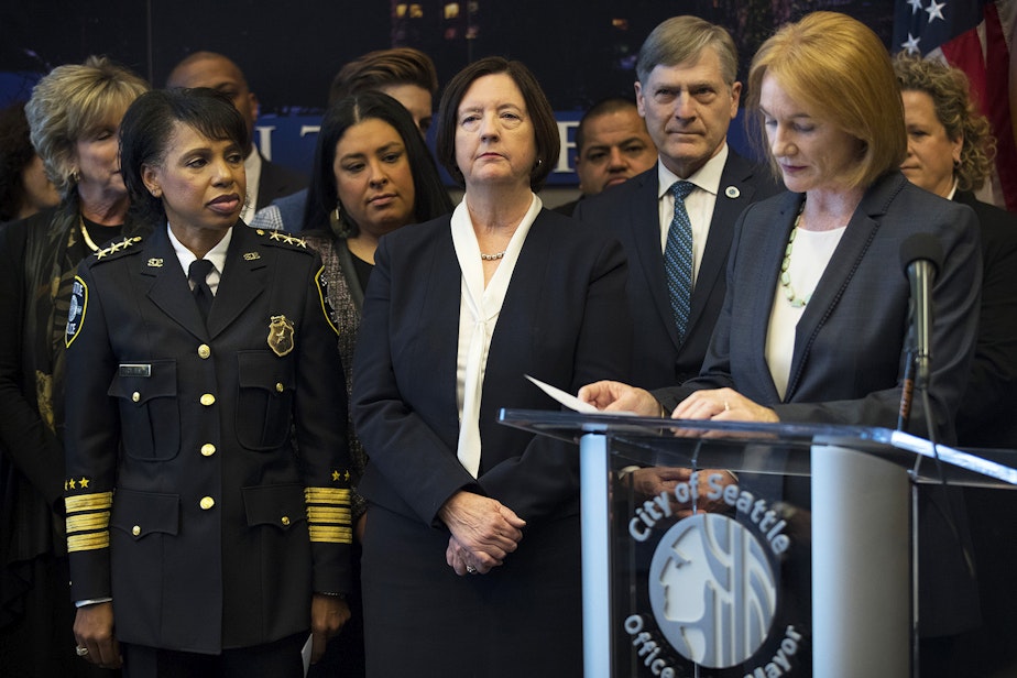 caption: FILE: Then-deputy Chief Carmen Best, left, and then-Seattle Police Chief Kathleen O'Toole listen as Mayor Jenny Durkan speaks during a press conference on Monday, December 4, 2017, at Seattle City Hall.