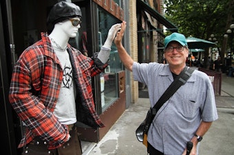 caption: Ross Reynolds having some fun while reporting a story in Seattle's Pioneer Square.