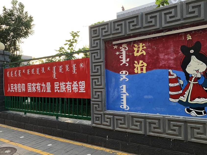 caption: A sign (left) outside a Mongolian-language school in Hohhot, Inner Mongolia, reads: "When the people have conviction, the state has strength and the ethnic minorities have hope." The sign at right says: "Rule of law."