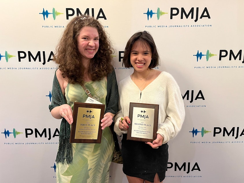 caption: RadioActive youth producers Simone St. Pierre Nelson and Charlotte Engrav accept awards at the Public Media Journalists Association (PMJA) annual awards banquet in Seattle, Washington on June 24, 2022.