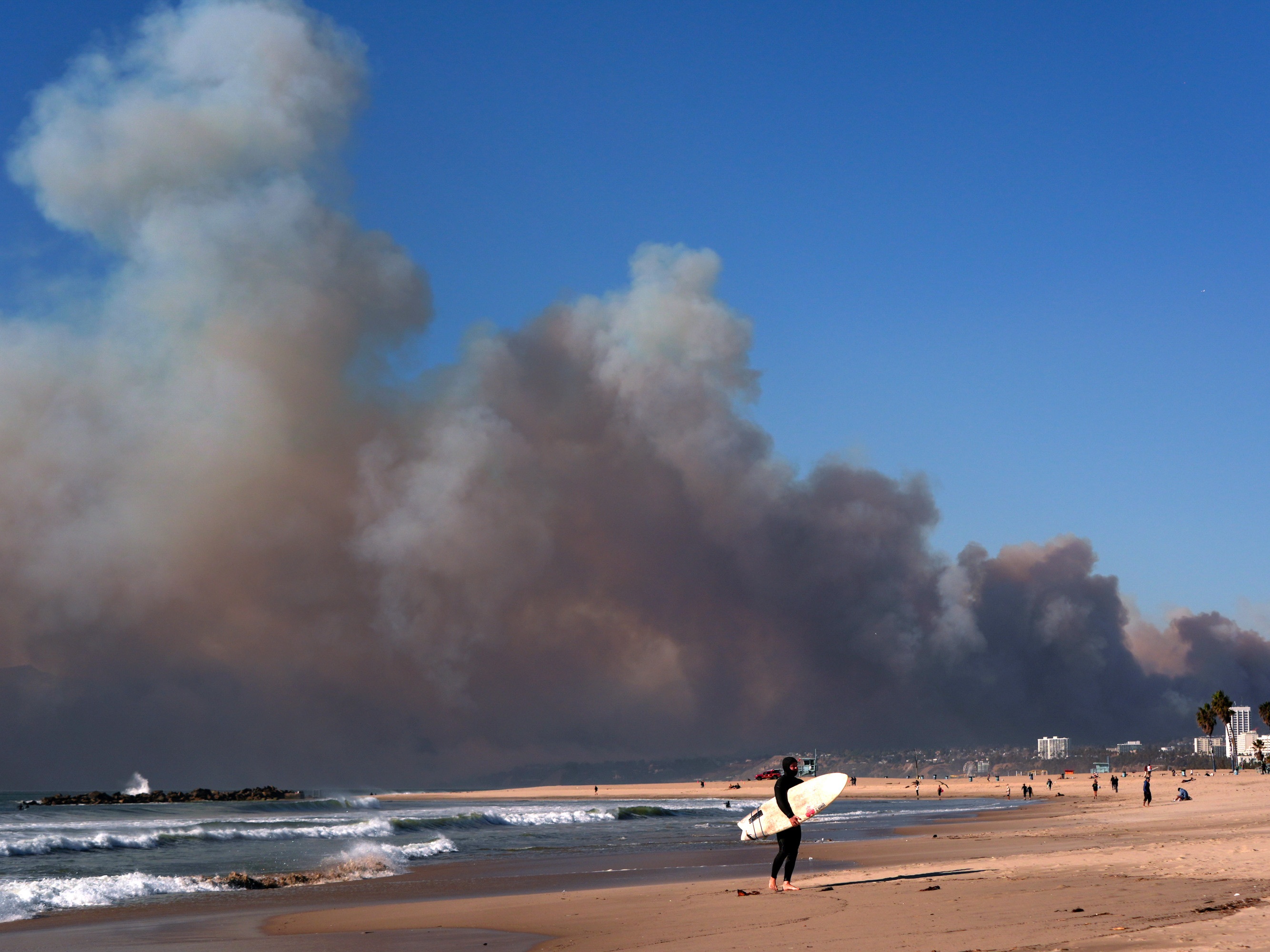 caption: Tuesday, Jan. 7: Smoke from a wildfire is seen from the Venice Beach section of Los Angeles, Calif.