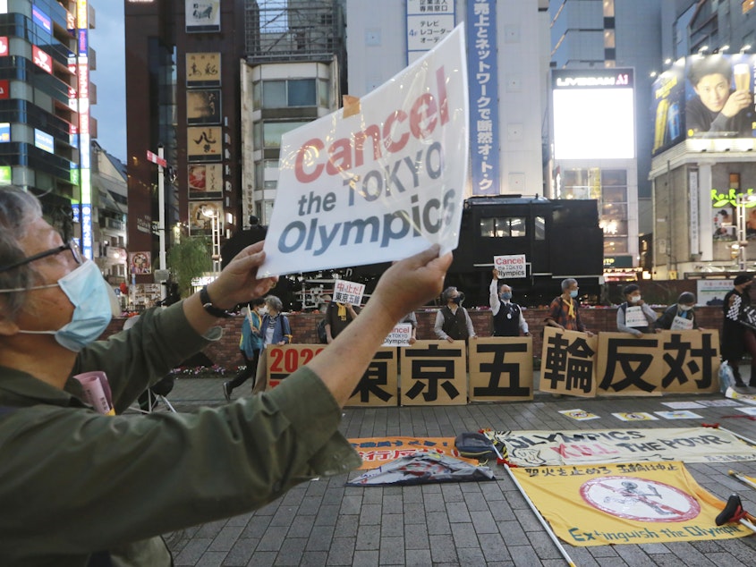 caption: A demonstrator holds a placard during an anti-Olympics demonstration in Tokyo on Monday. A prominent doctors association has joined calls to cancel the Summer Games in Tokyo.
