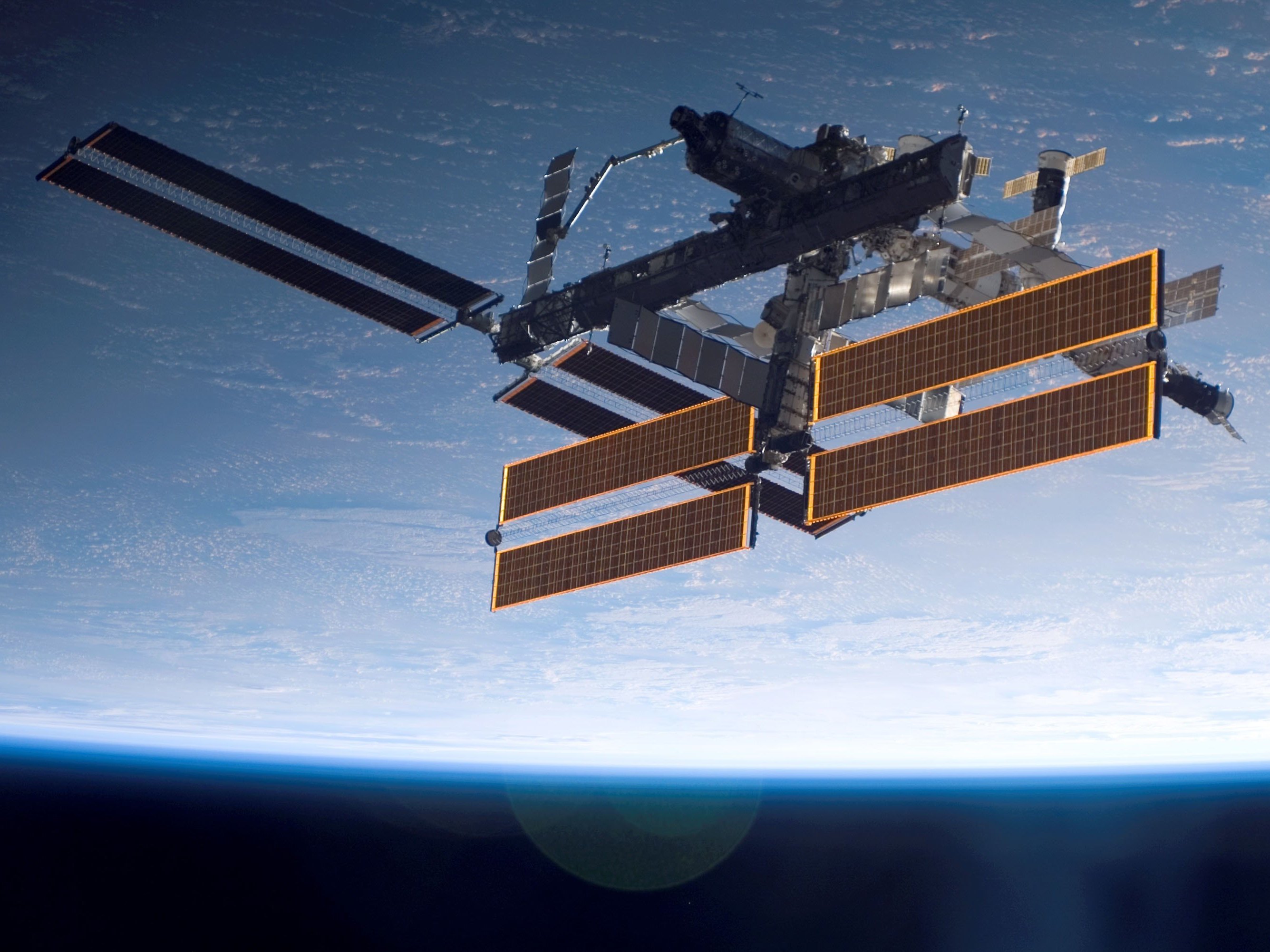 caption: International Space Station is seen over a blue and white Earth, taken shortly after the Space Shuttle Atlantis undocked from the orbital outpost.