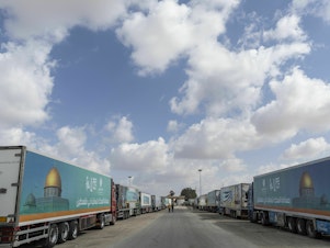 caption: Aid convoy trucks wait at the Rafah border crossing for clearance to enter Gaza on Thursday in North Sinai, Egypt. The aid convoy, organized by a group of Egyptian NGOs, set off Saturday from Cairo for the Gaza-Egypt border crossing at Rafah.