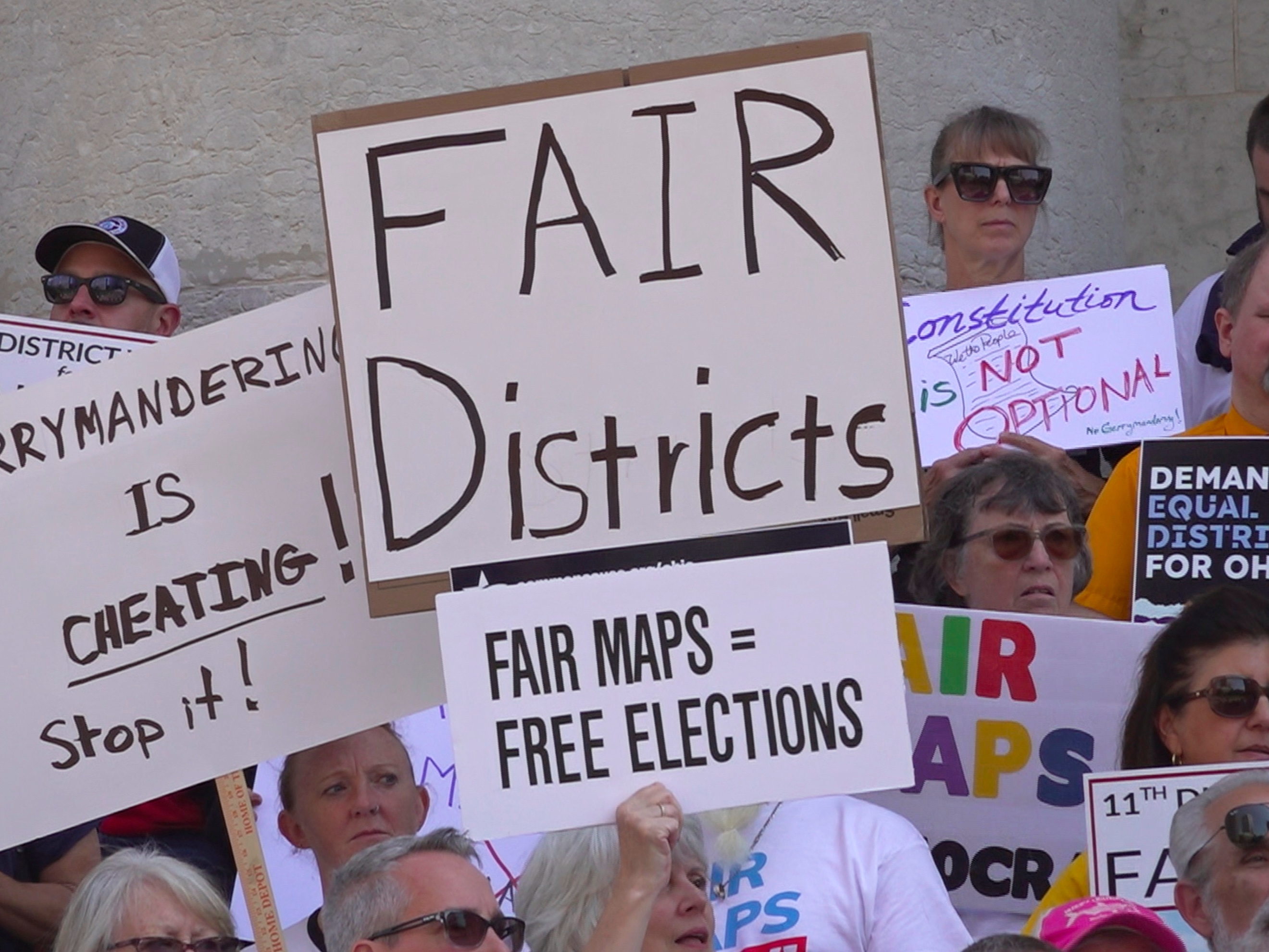 caption: Demonstrators rally outside of the Ohio Statehouse to protest gerrymandering and advocate for lawmakers to draw fair maps in September in Columbus, Ohio.