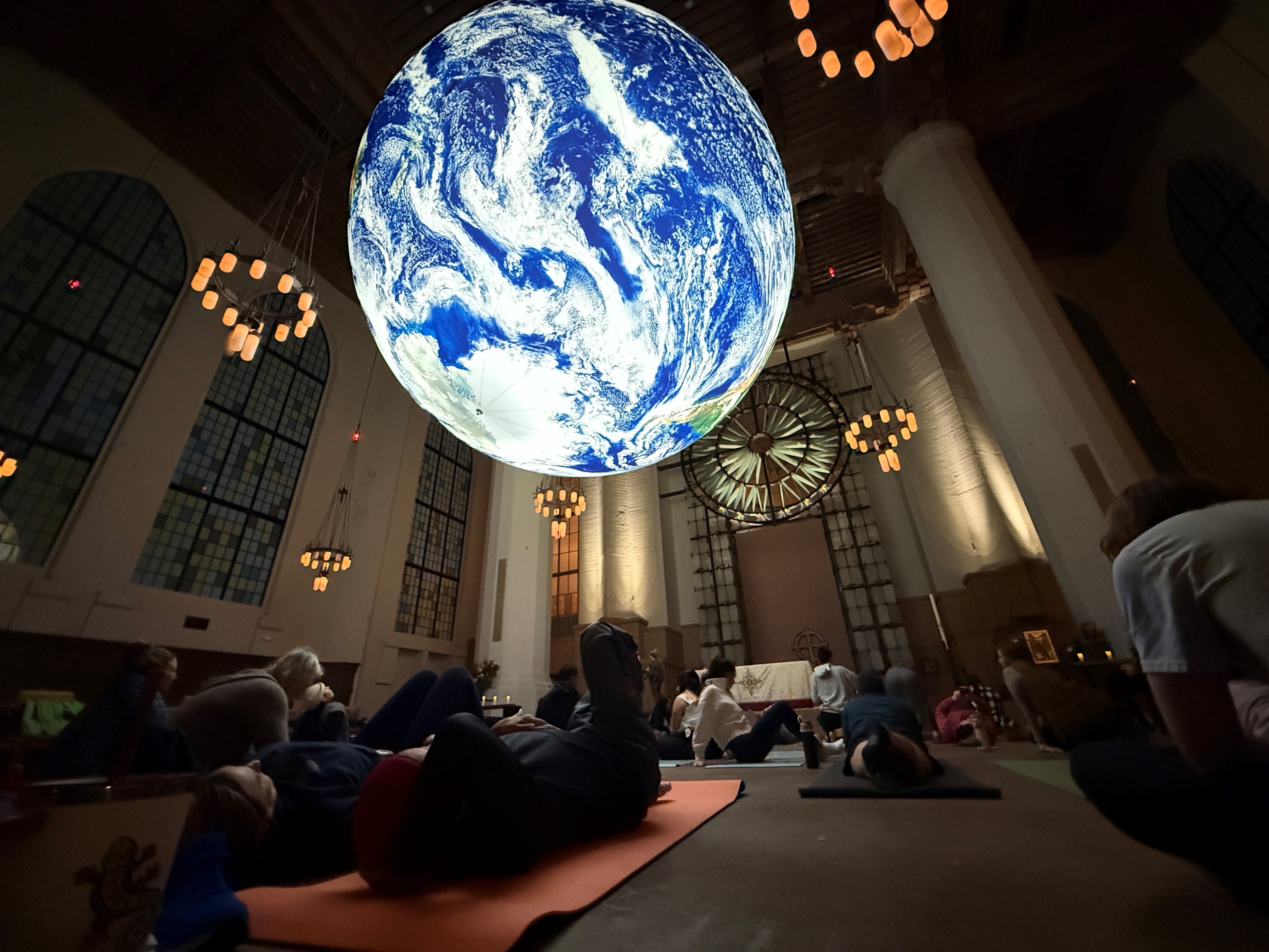 caption: The yoga class meets under the TERRA exhibition. 