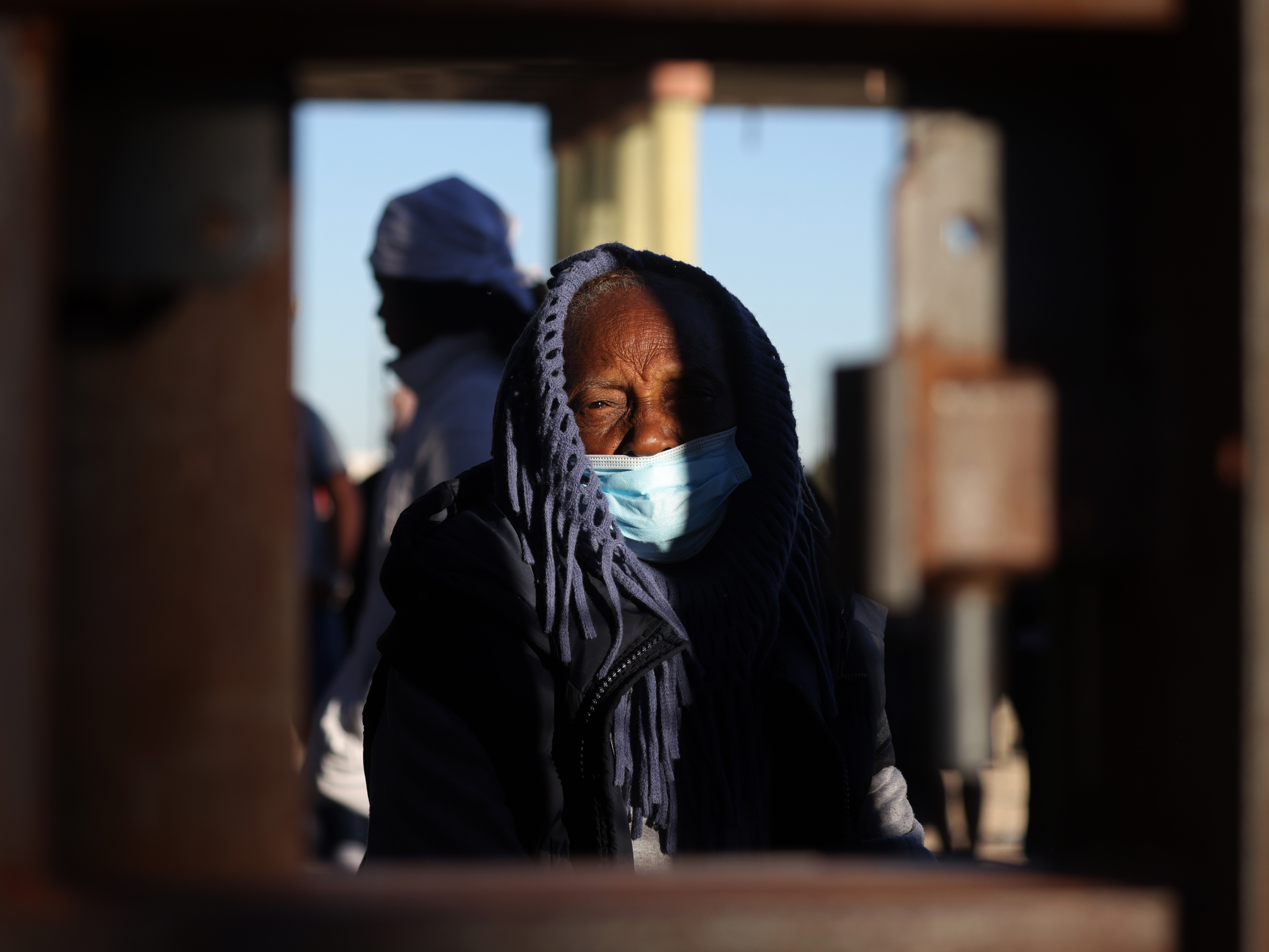 caption: An asylum-seeking migrant from Nicaragua bundles up at the border as she waits to be processed by U.S. Customs and Border Protection after crossing the Rio Grande River into the United States in El Paso, Texas, U.S., December 22, 2022.