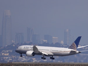 caption: A United Airlines 787 Dreamliner lands at San Francisco International Airport on Oct. 19, 2021.