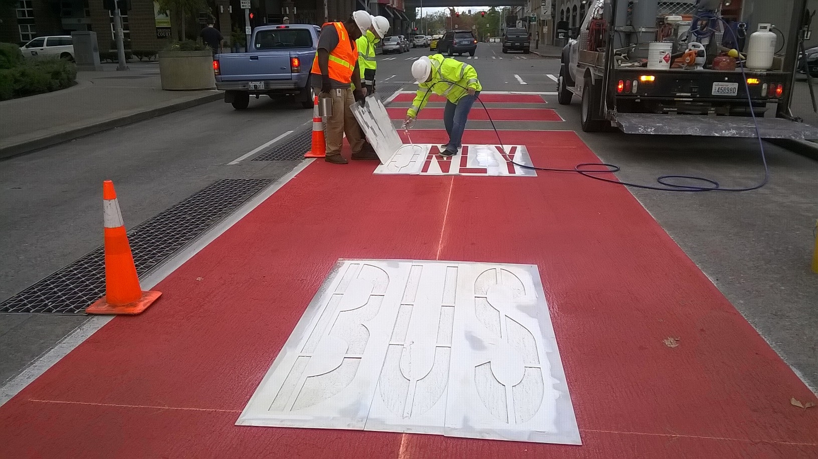 caption: An SDOT Crew puts the finishing touches on a bus-only lane on Battery Street in Seattle's Belltown Neighborhood.
