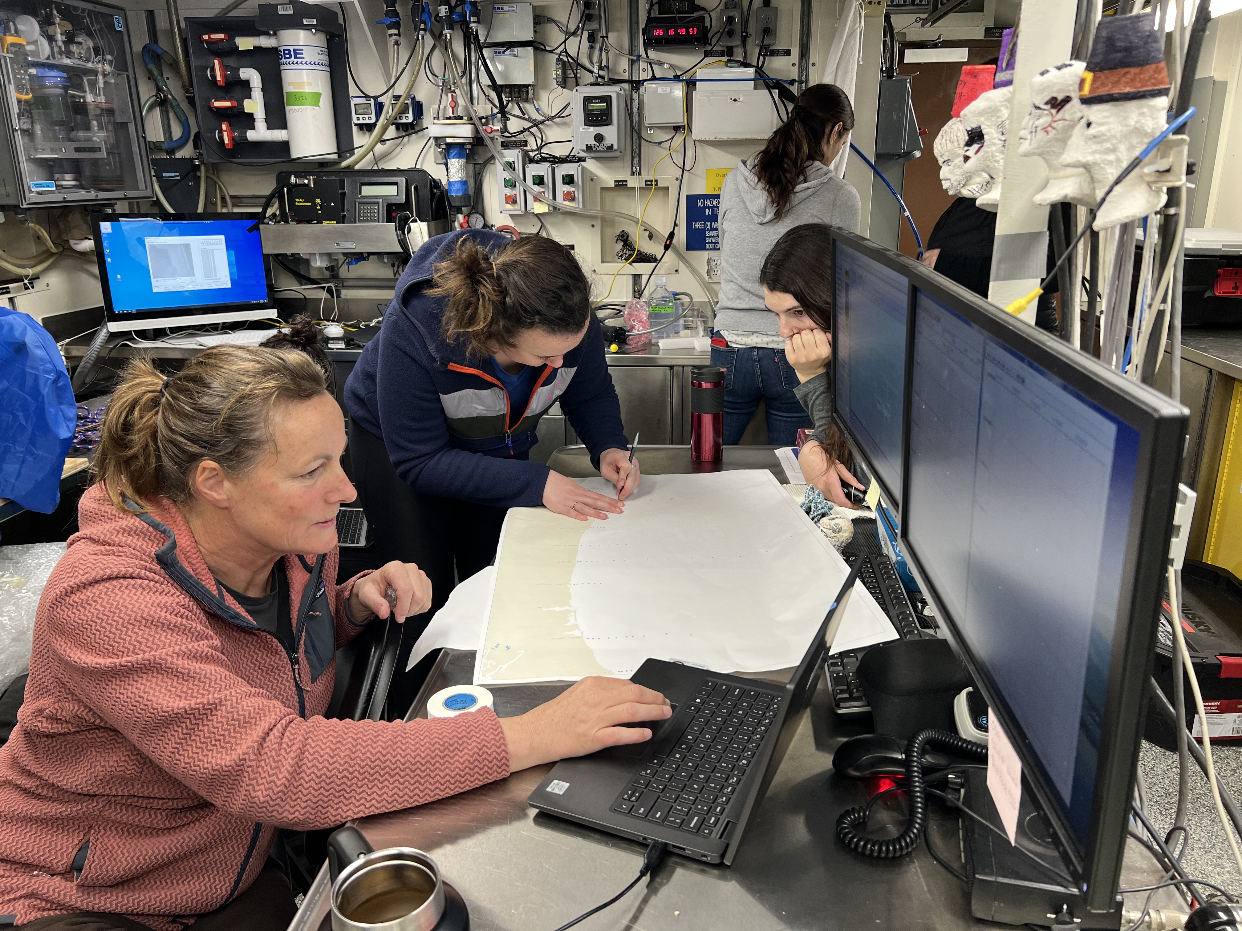 caption:  Scientists Jennifer Fisher and Clara Bird map out sampling stations along the Oregon and Washington coasts.