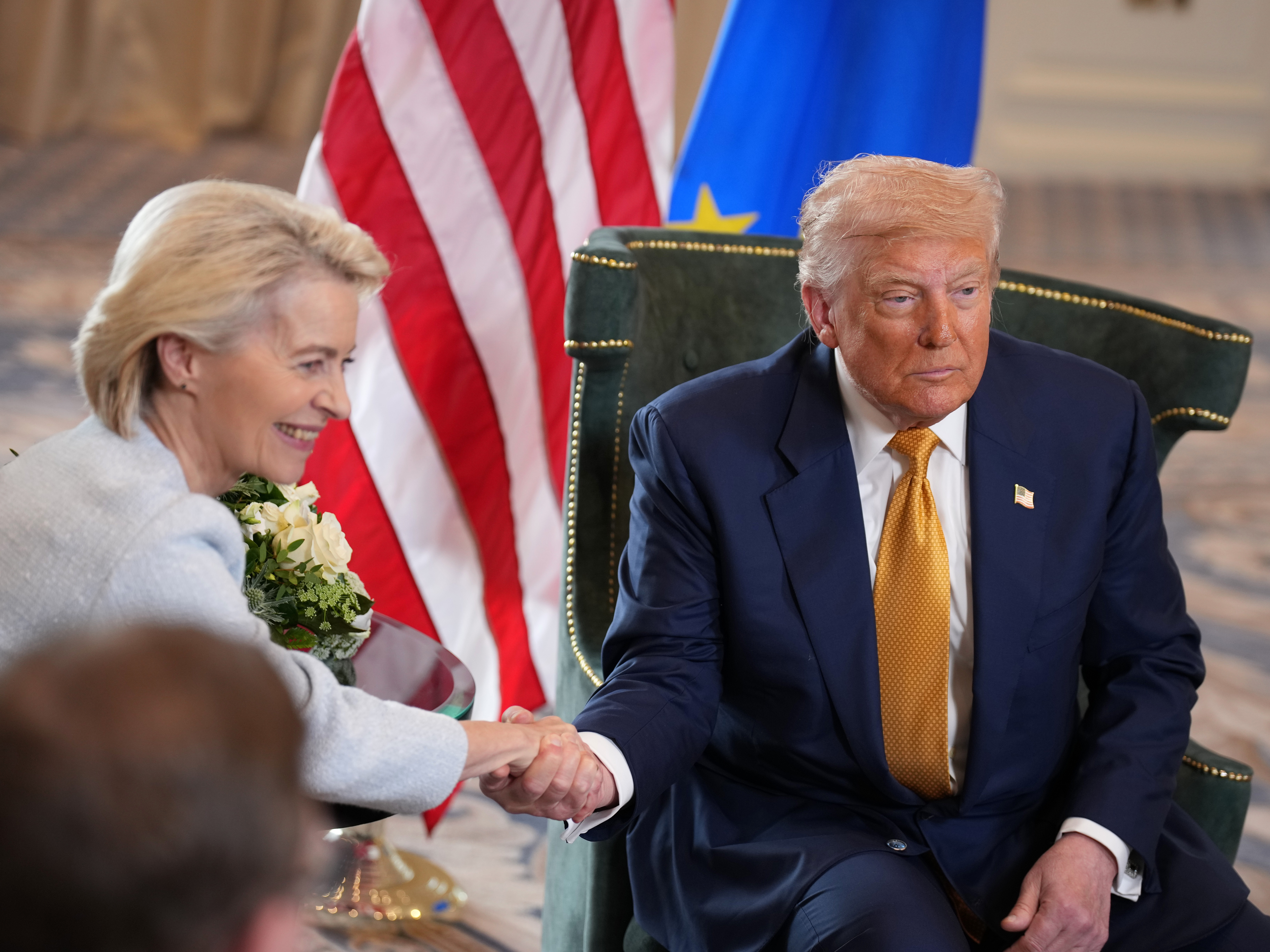 caption: President Donald Trump shakes hands with President of the European Commission Ursula von der Leyen as he announces a trade deal with the EU at Trump Turnberry golf club on July 27, 2025 in Turnberry, Scotland.