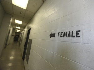 caption: A sign points toward the women's section of the Huntington Beach jail. The National Council for Incarcerated and Formerly Incarcerated Women and Girls is appealing to President Biden to grant clemency to 100 women during his first 100 days in office.