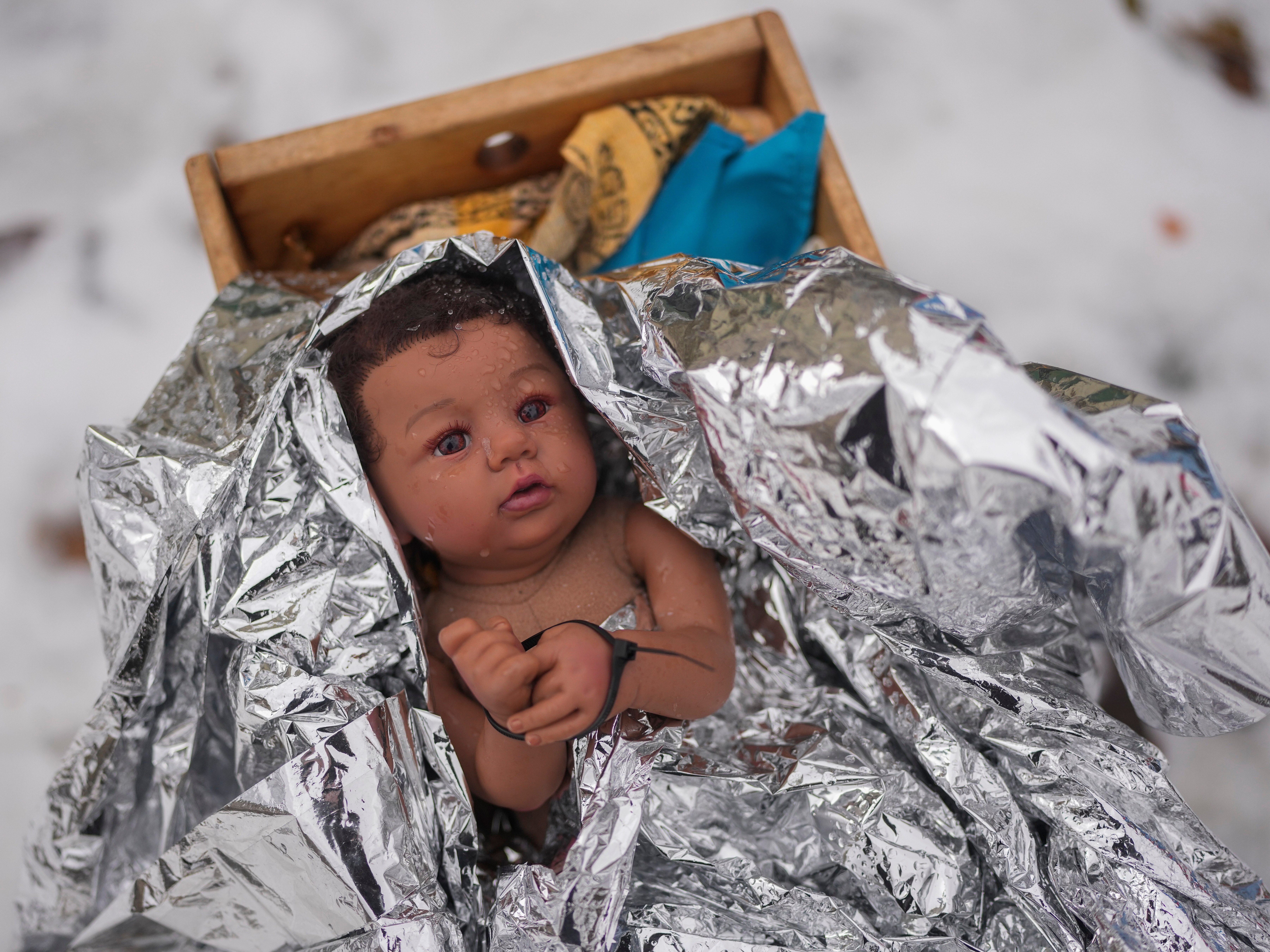 caption: A doll representing the baby Jesus is zip-tied in the Nativity scene outside of Lake Street Church of Evanston, on Wednesday in Evanston, Ill.