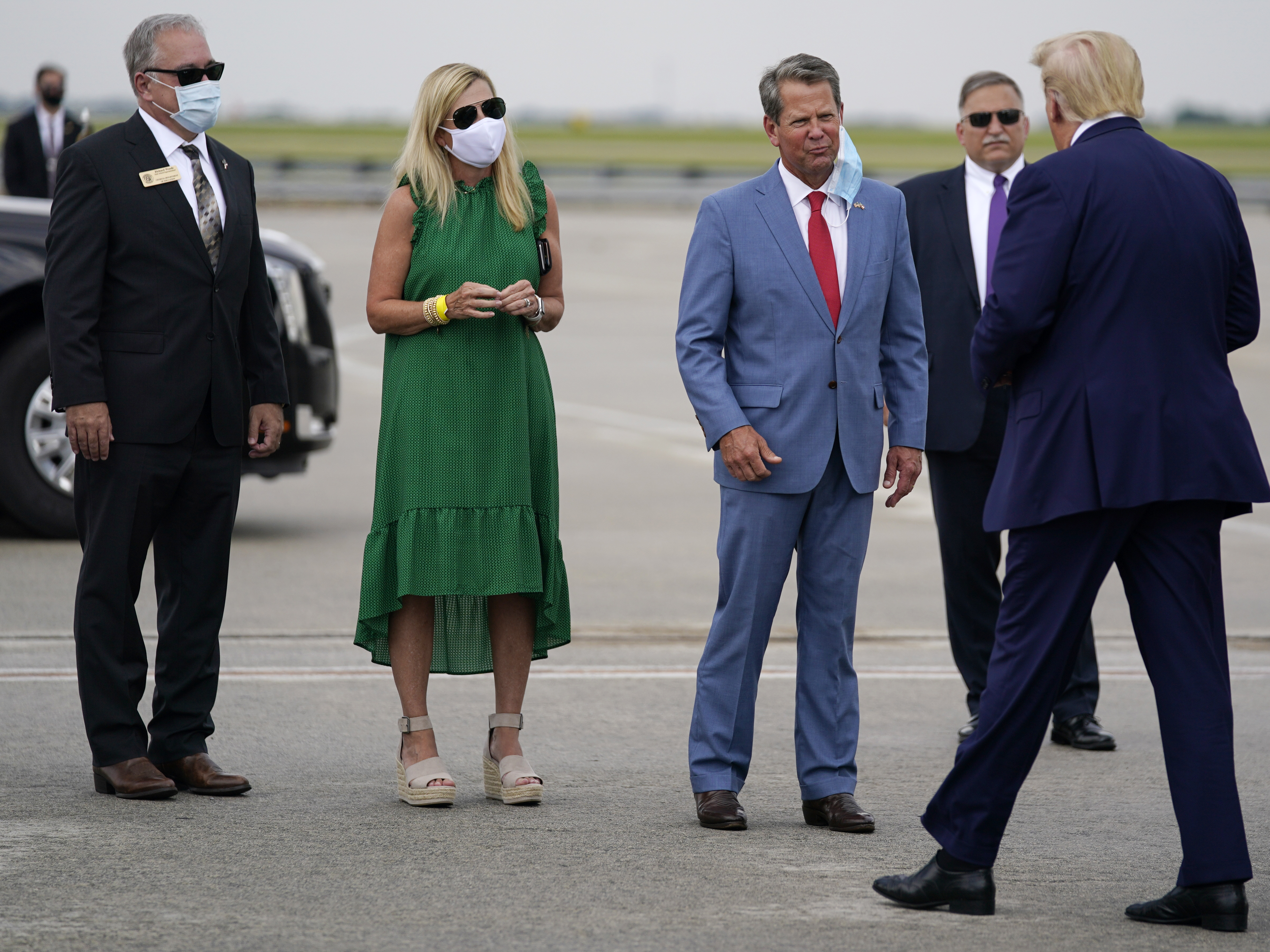 caption: Georgia Gov. Brian Kemp (third from left) greets President Trump at Hartsfield-Jackson Atlanta International Airport on Wednesday.