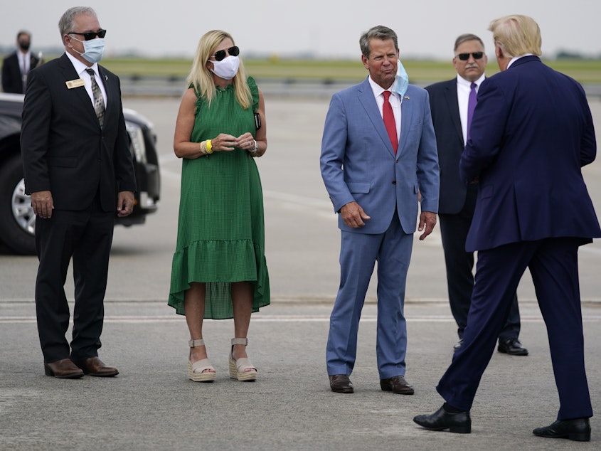 caption: Georgia Gov. Brian Kemp (third from left) greets President Trump at Hartsfield-Jackson Atlanta International Airport on Wednesday.