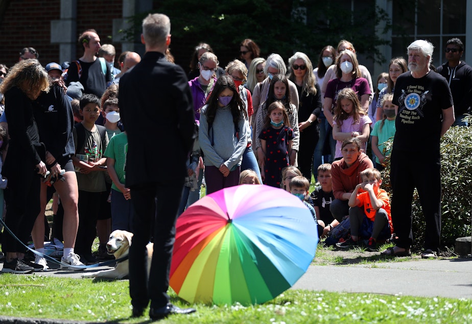 caption: A moment of silence is led by kindergarten teacher Kevin Gallagher on Wednesday, May 15, 2022, at Bryant Elementary School in Seattle. 