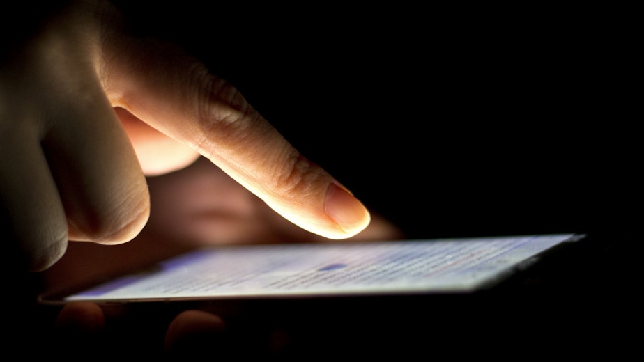 caption: A woman uses her smartphone.