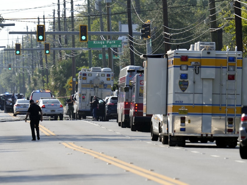 caption: Authorities respond to the scene of a mass shooting at a Dollar General store, Saturday, in Jacksonville, Fla.