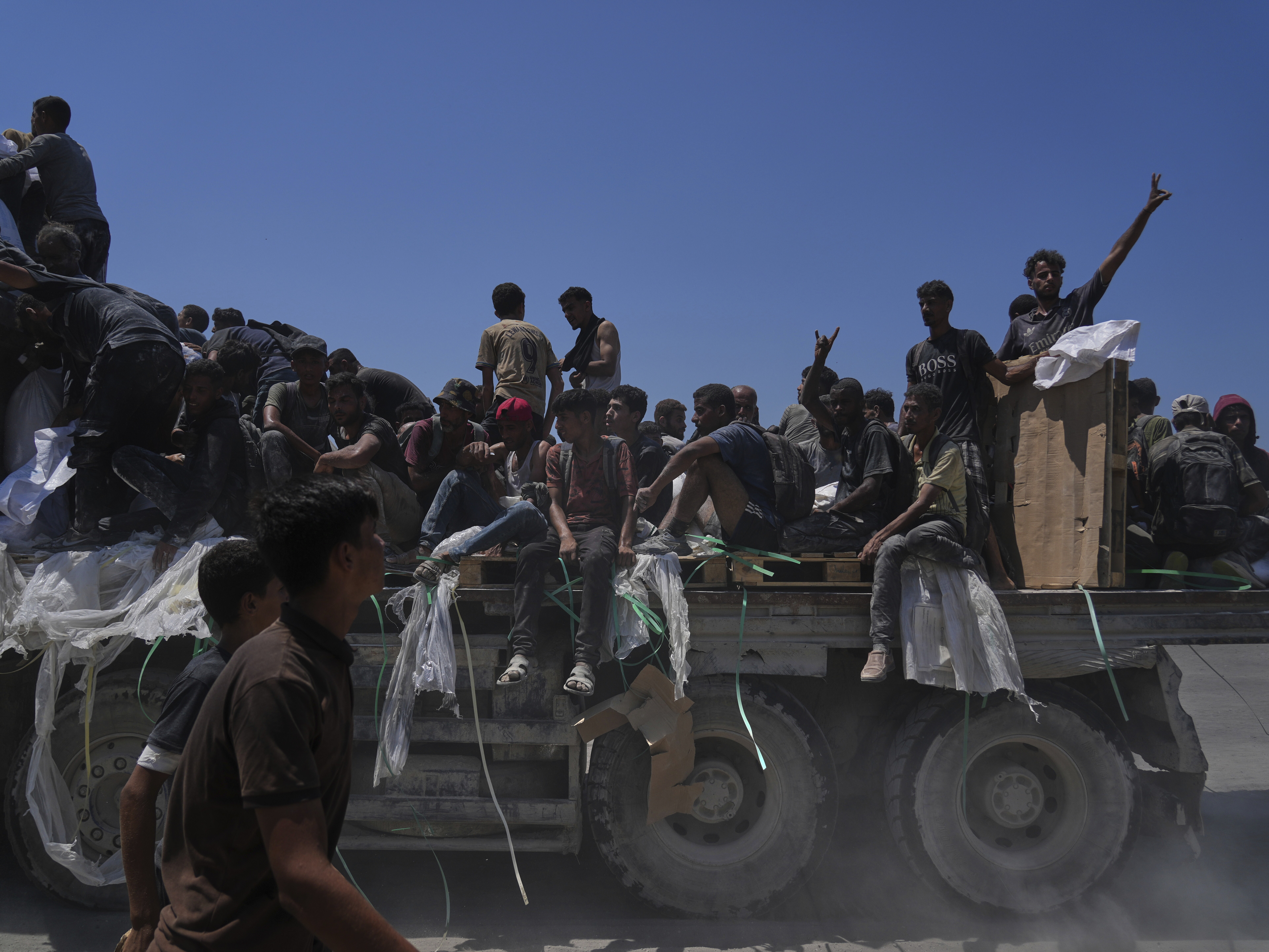 caption: Palestinians hold onto an aid truck returning to Gaza City from the northern Gaza Strip, Sunday.