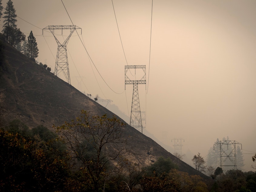 caption: California utility PG&E Corp. said Monday that it plans to file for bankruptcy over what it estimates could be $30 billion in potential liability costs from recent wildfires. Here, transmission towers in a valley near Paradise, Calif., as the Camp Fire burns in November 2017.