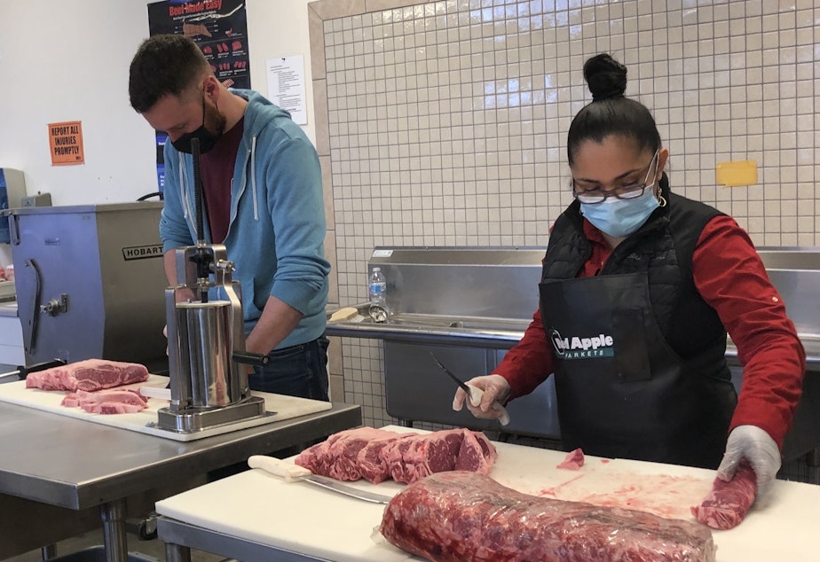 caption: PCC employees Trevor Howard, left, and Ana Cuevas demonstrate the skills they learned through an apprenticeships program for meat cutters at South Seattle College. 