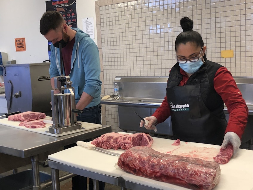 caption: PCC employees Trevor Howard, left, and Ana Cuevas demonstrate the skills they learned through an apprenticeships program for meat cutters at South Seattle College. 