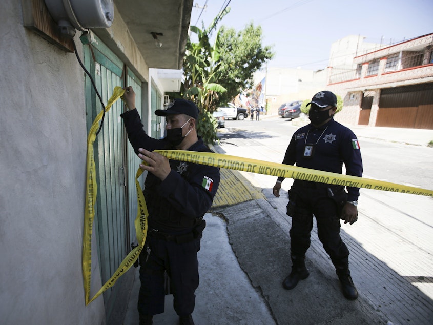 caption: Police mark a security perimeter around the house where bones were found under the floor in the Atizapan municipality of the State of Mexico, on May 20, 2021. Police have turned up bones and other evidence under the floor of the house where a man was arrested for allegedly stabbing a woman to death and hacking up her body.