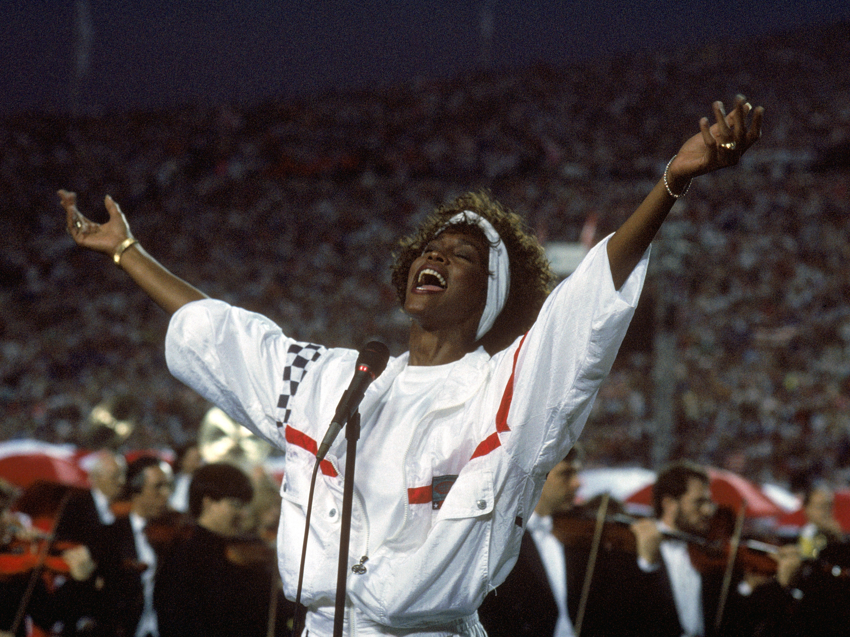 caption: At Florida's Tampa Stadium in 1991, Whitney Houston delivered an iconic performance of "The Star Spangled Banner" to kick off Super Bowl XXV.