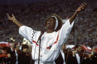 caption: At Florida's Tampa Stadium in 1991, Whitney Houston delivered an iconic performance of "The Star Spangled Banner" to kick off Super Bowl XXV.