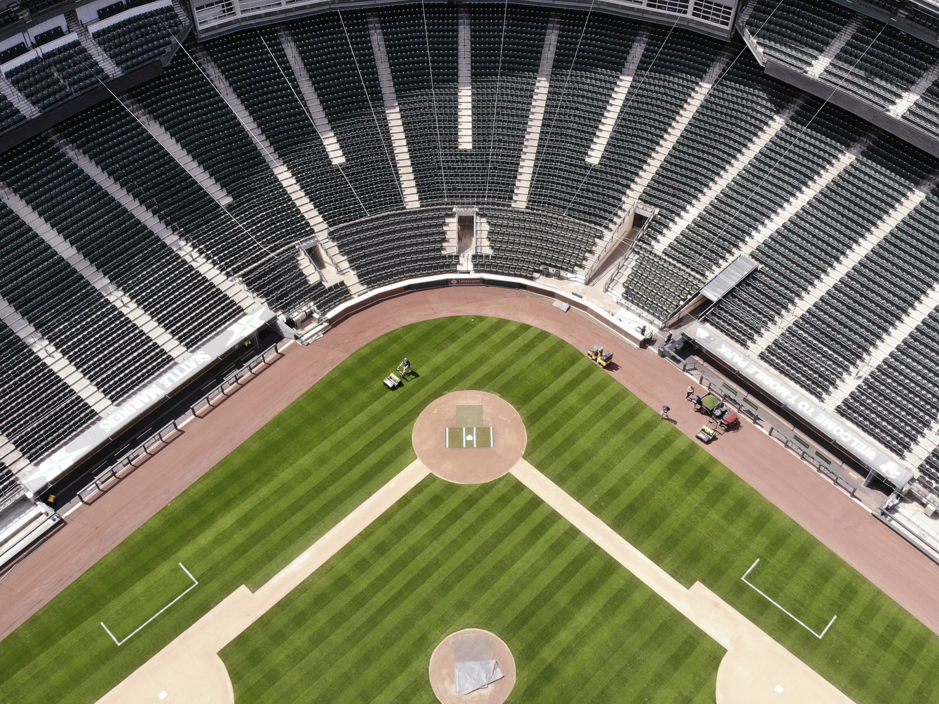 caption: Grounds crews maintain the field at an otherwise empty Seattle Mariners' ballpark on Monday, May 11, 2020.