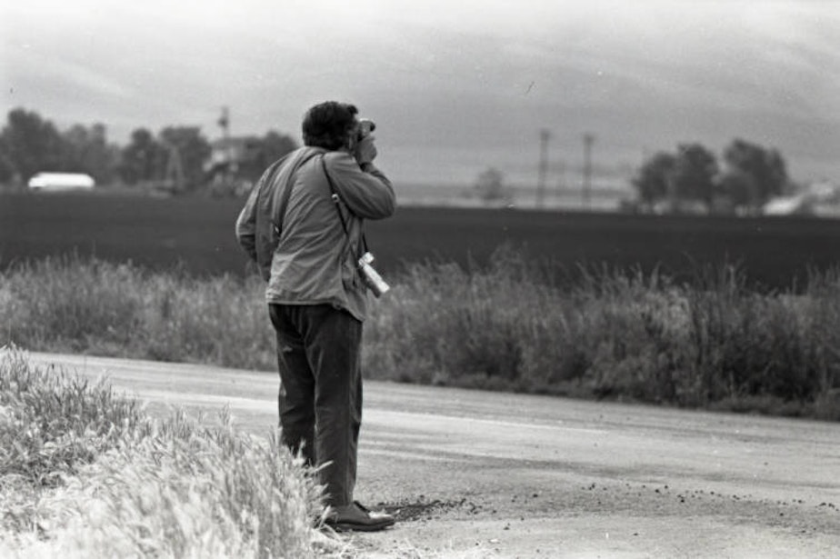 caption: Irwin Nash taking photos of a field near Rogers Walla Walla Labor Camp, in 1971.