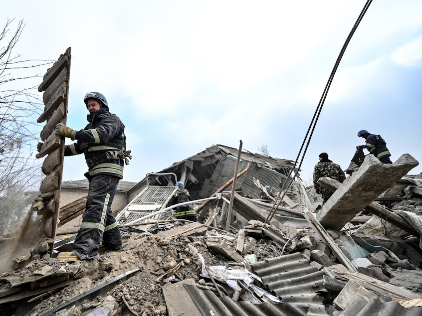 caption: Rescuers remove rubble at the maternity ward of the Vilniansk Multidisciplinary Hospital in Ukraine, one of the countries experiencing an increase in violence against health-care workers.