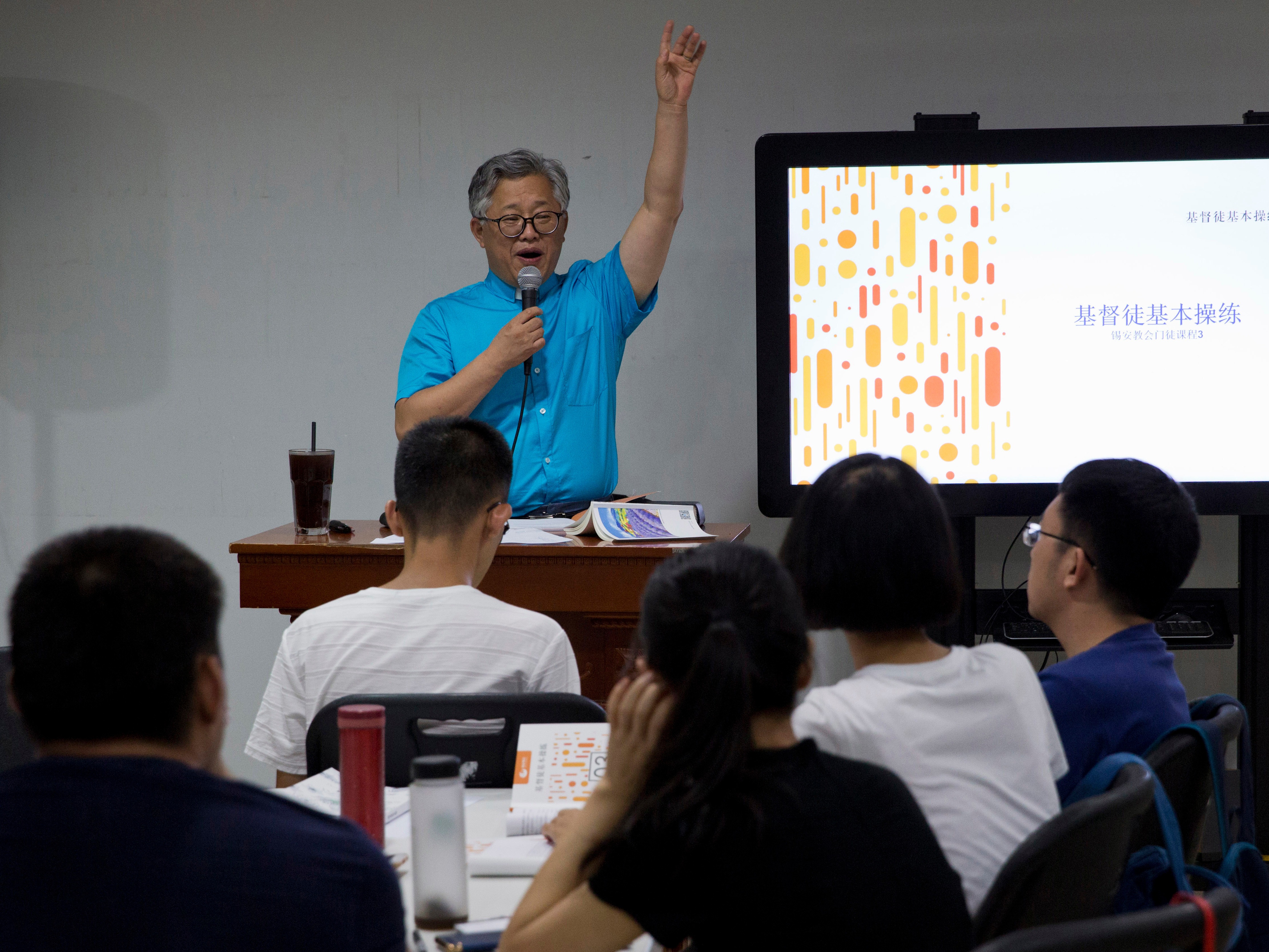 caption: Pastor Ezra Jin leads a class on the basics of Christian beliefs at the Zion Church in Beijing, China, in August 2018.
