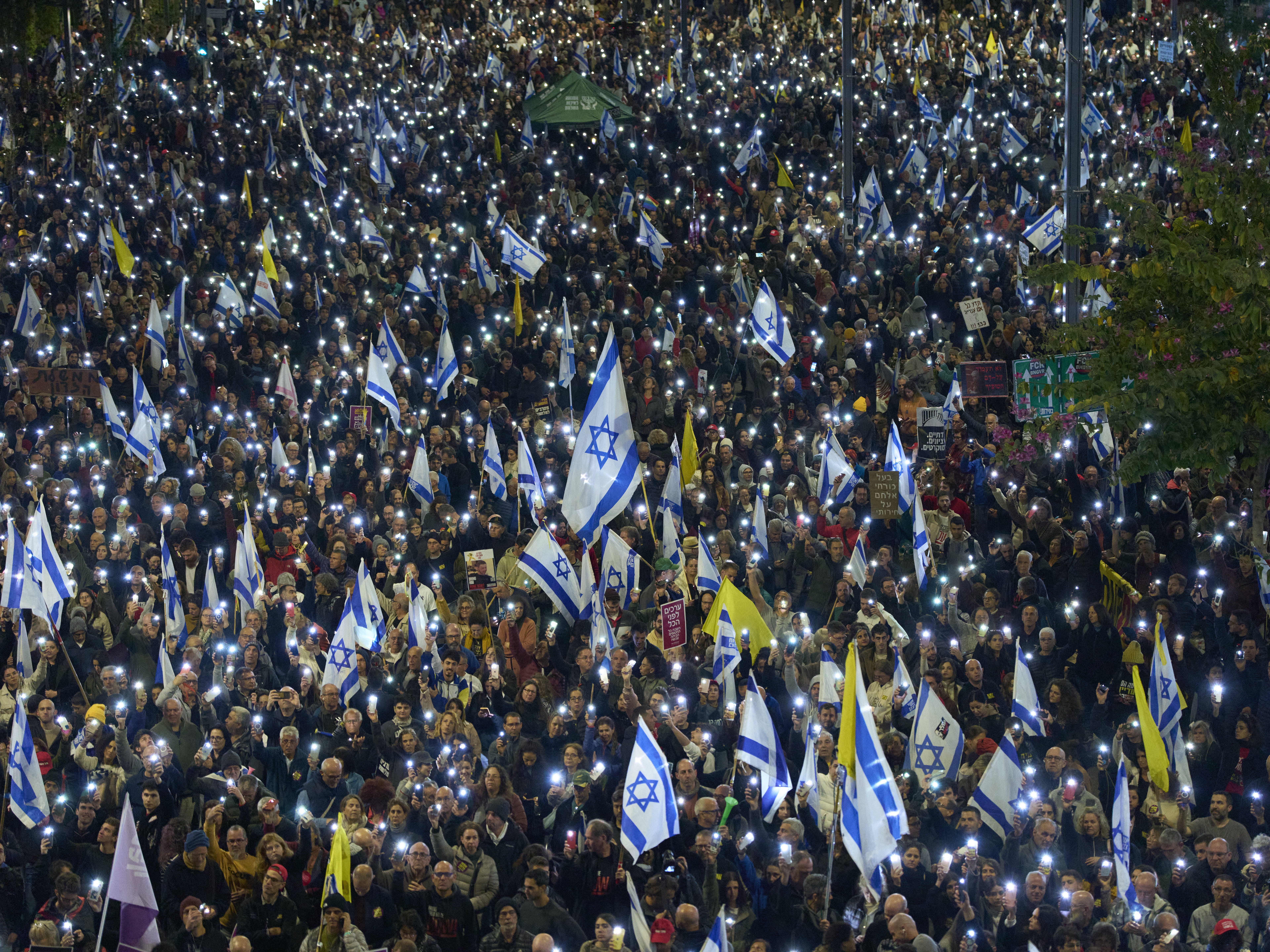 caption: People take part in a protest demanding the immediate release of hostages held by Hamas in the Gaza Strip, in Tel Aviv, Israel, Saturday.