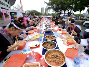 caption: Above: locals in Liuzhou feast on their regional specialty of snail noodles. The novelty of the dish has made it a viral sensation in China during the pandemic.