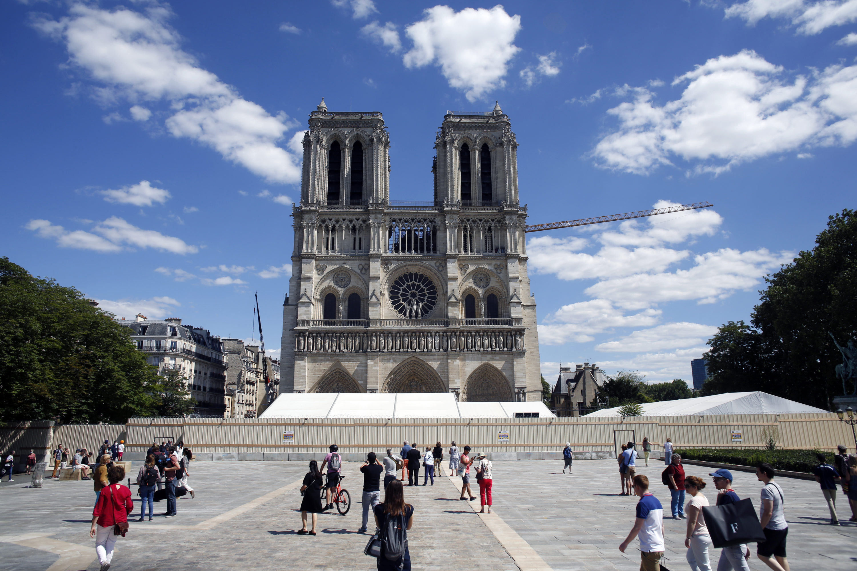 caption: People walk on the forecourt of Notre Dame's Cathedral, in Paris, Sunday, May 31, 2020. Notre Dame Cathedral's forecourt is being opened up to the public for the first time since the devastating fire of April 15 last year. (Thibault Camus/AP)