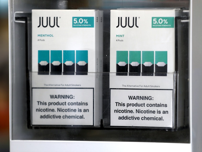 caption: Packages of Juul mint-flavored e-cigarettes are displayed at a smoke shop in 2019.