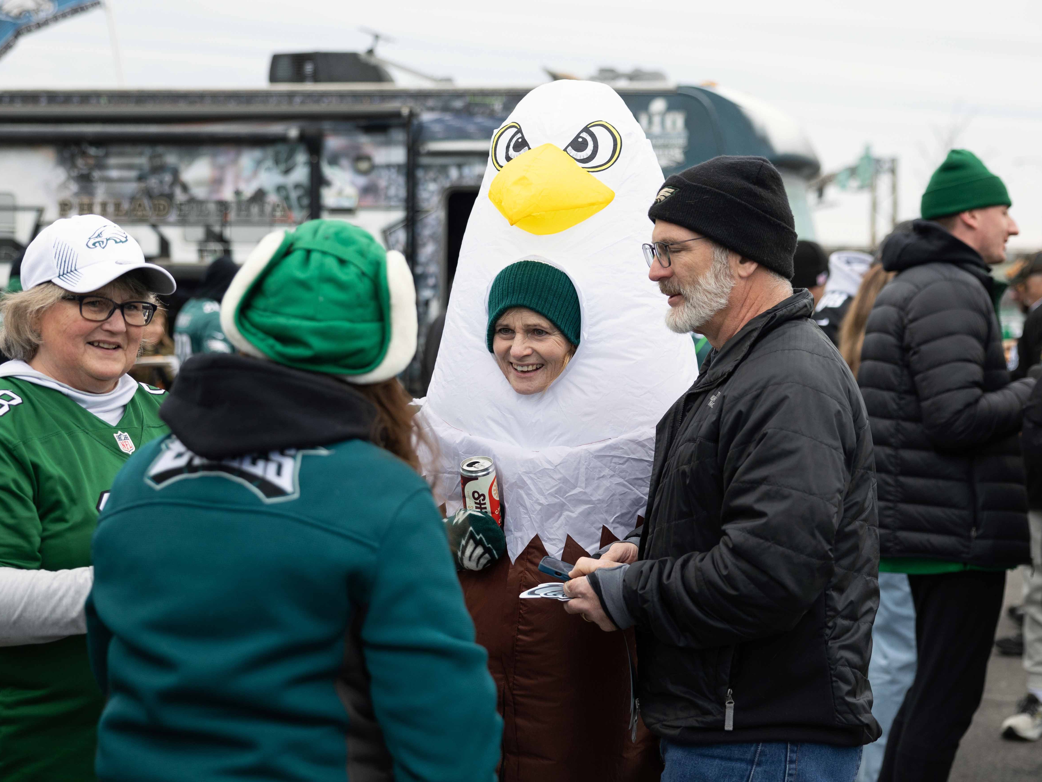 caption: Susan Klabunde (center) dons an eagle costume at a tailgate before the NFC championship game at Lincoln Financial Field in Philadelphia.