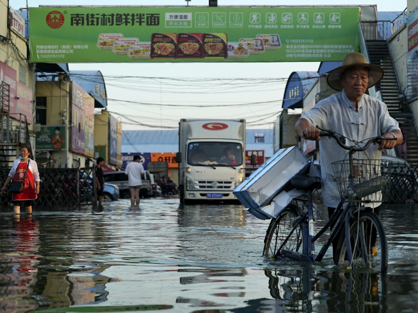 caption: Xinxiang, in China's Henan Province on July 26, was one of many places that suffered extreme flooding this year. A U.N reports finds climate impacts are getting worse faster than countries can adapt.